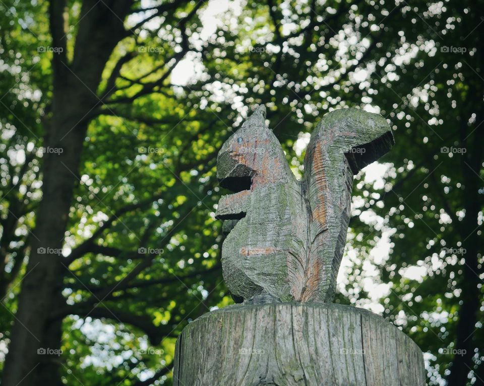 Wooden squirrel figure in forest