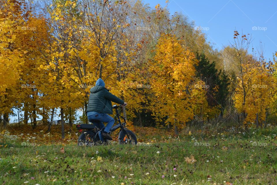 men riding on a electric bike autumn landscape,