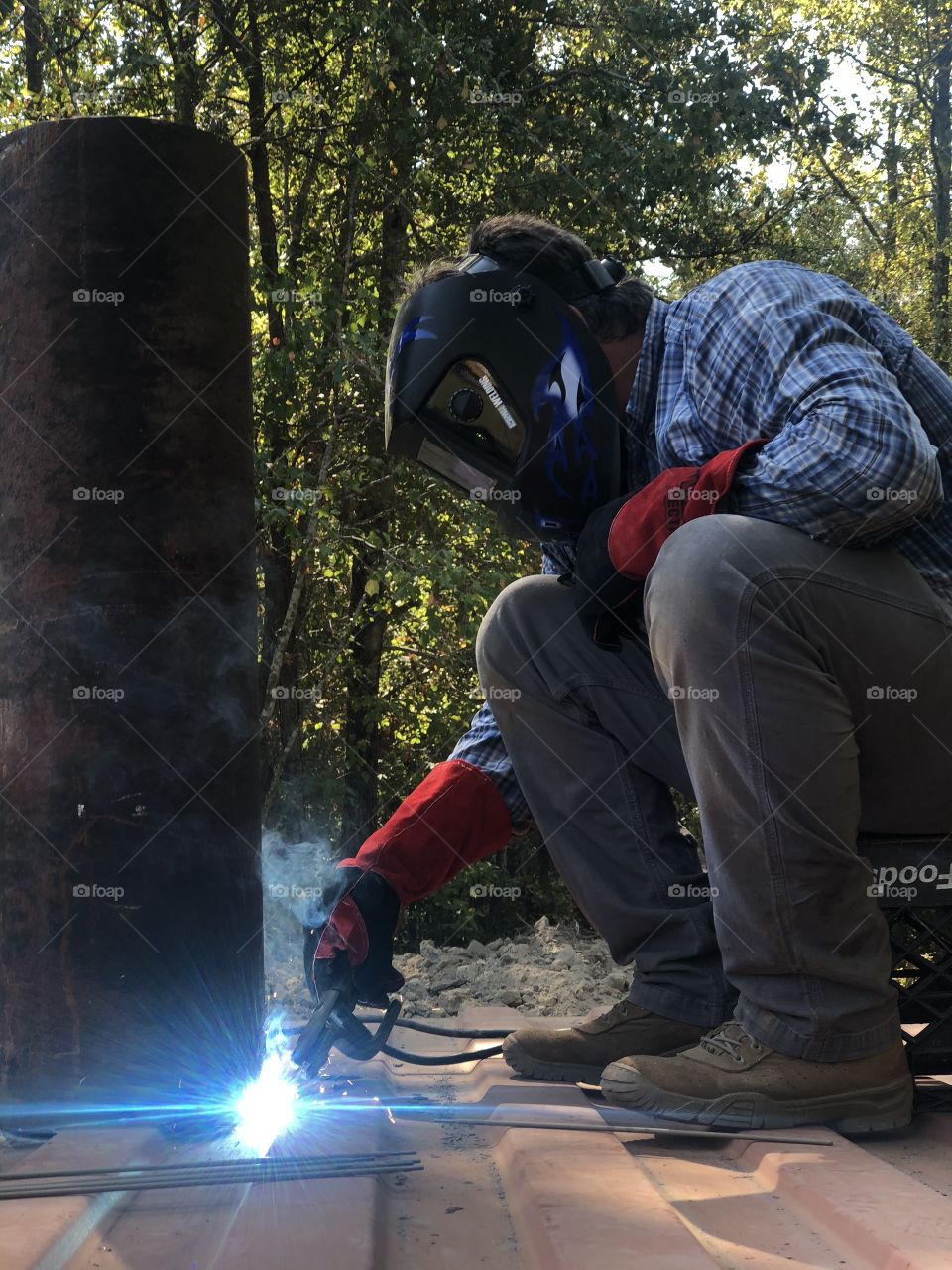 Installing a storm shelter- man welding ventilation turbines