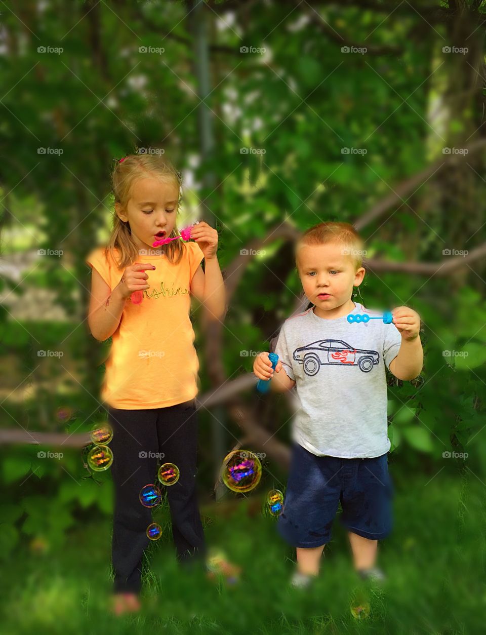 Blowing Bubbles. Boy and girl blowing bubbles