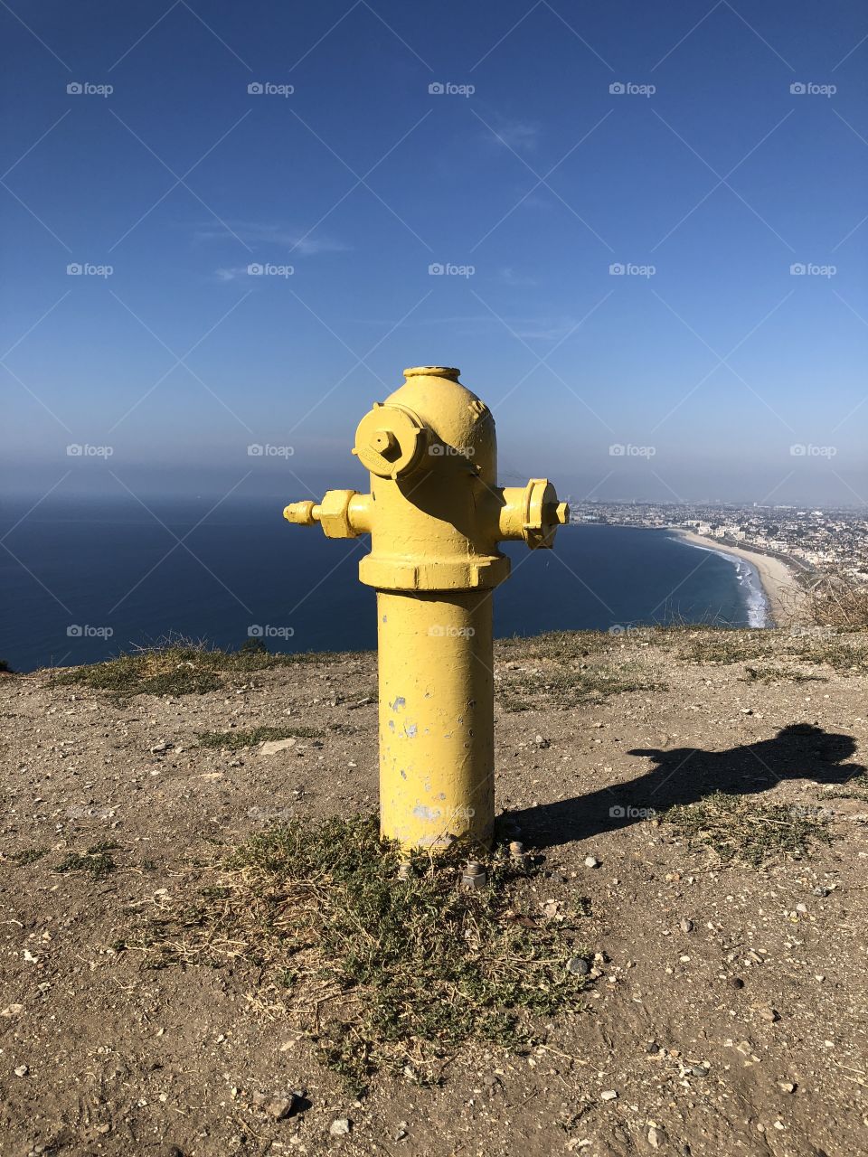 Yellow fire hydrant overlooking beach city 