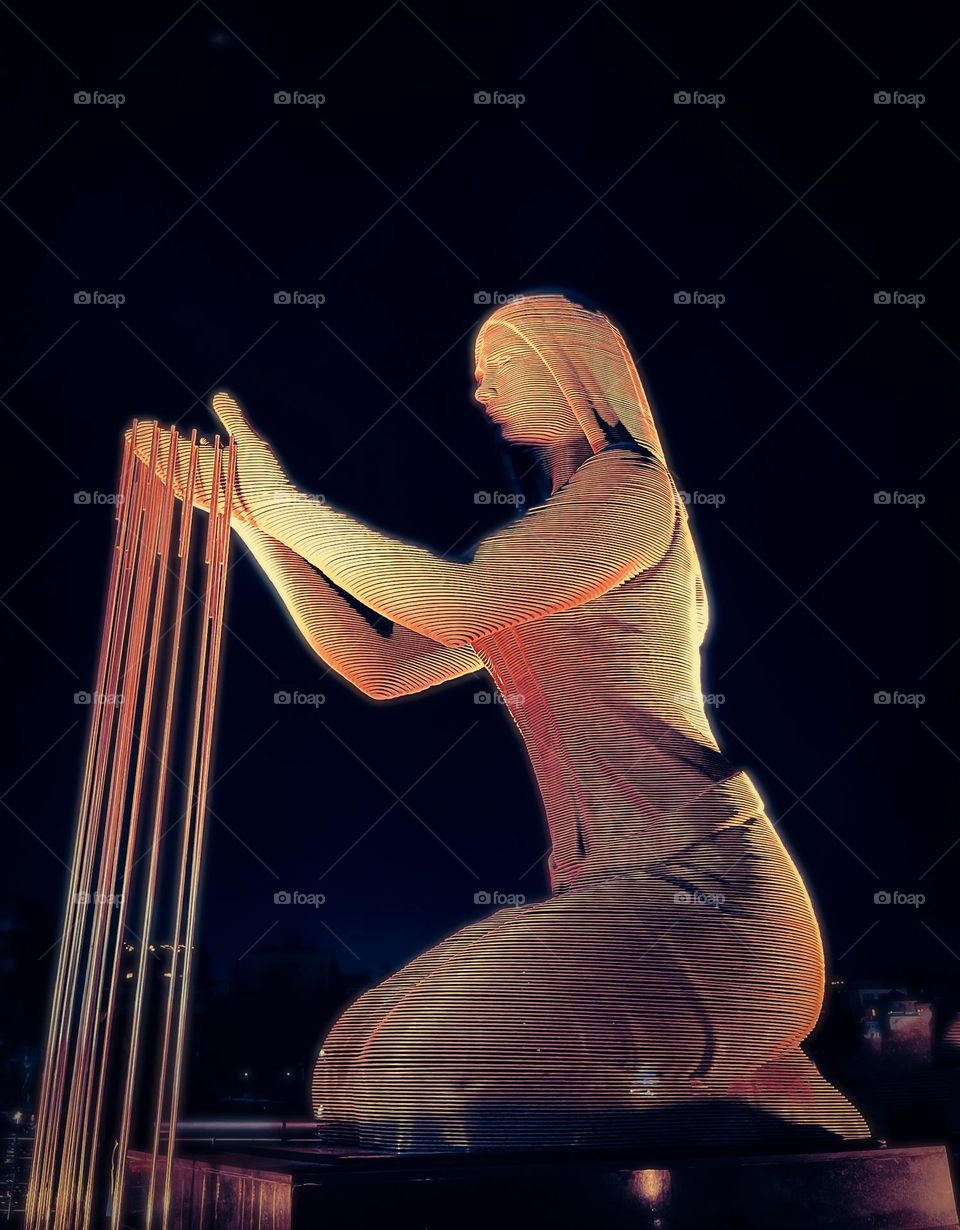 Iron statue of a woman who sits and raises her hand as if she were receiving water from the sky to irrigate the earth – a sign of the greatness of the River Nile. Cairo, Egypt.