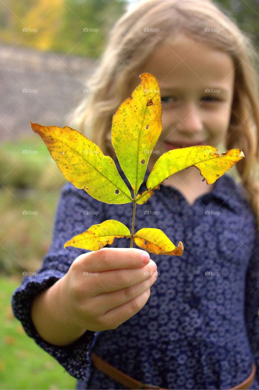 Close-up of a girl holding green leaf