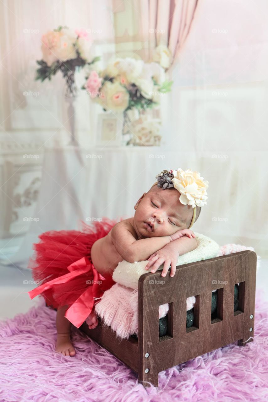 A baby who is sleeping soundly on a tiny bed