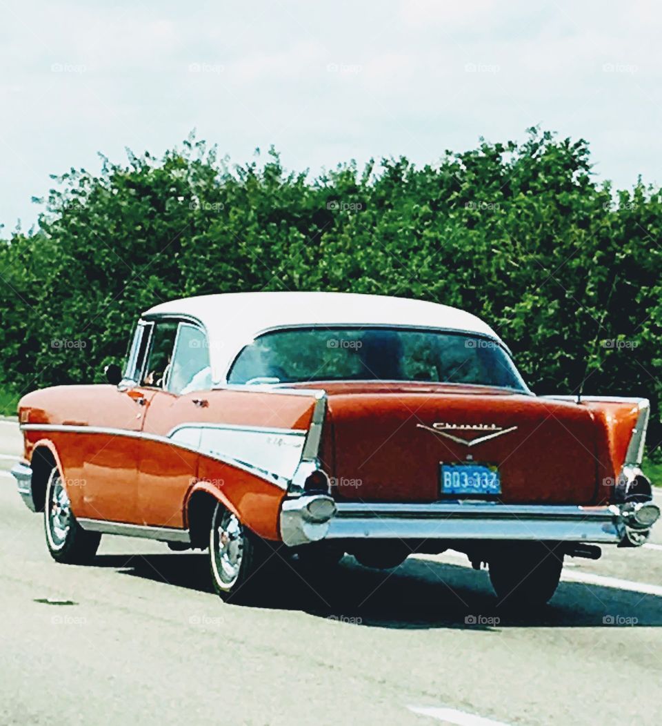 57 Chevy hardtop, 4-door, red & white color. Photo taken as it's being driven on highway!🚘
