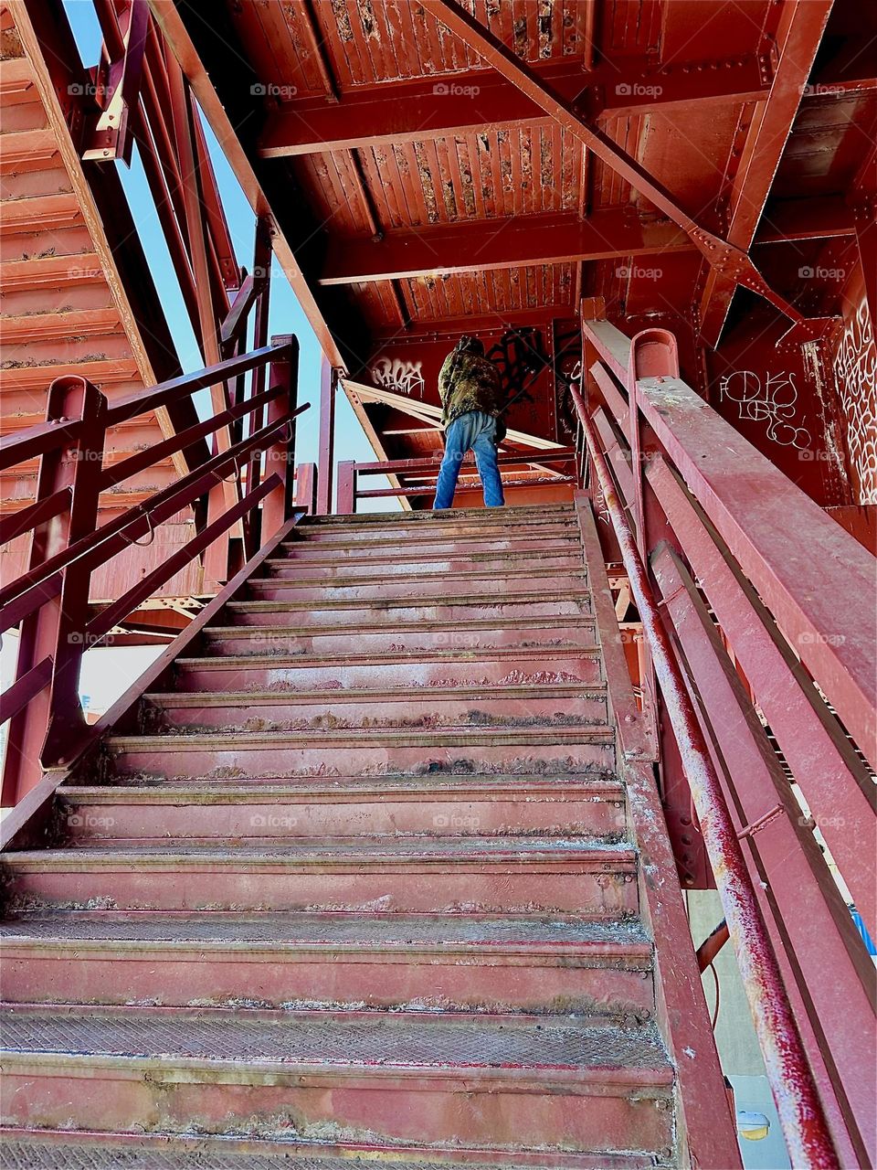 This is the red metal staircase of the “Pulaski Bridge” at “Newtown Creek” in LIC, Queens. The industrial minimalist design style reminds of the “Bauhaus” school of the 1930s. 2024. Hypnotic Productions