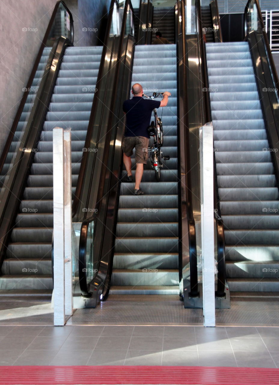 man with bike on rscalator