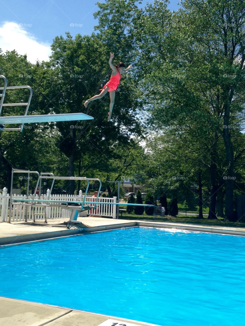 Small girl jumping in swimming pool