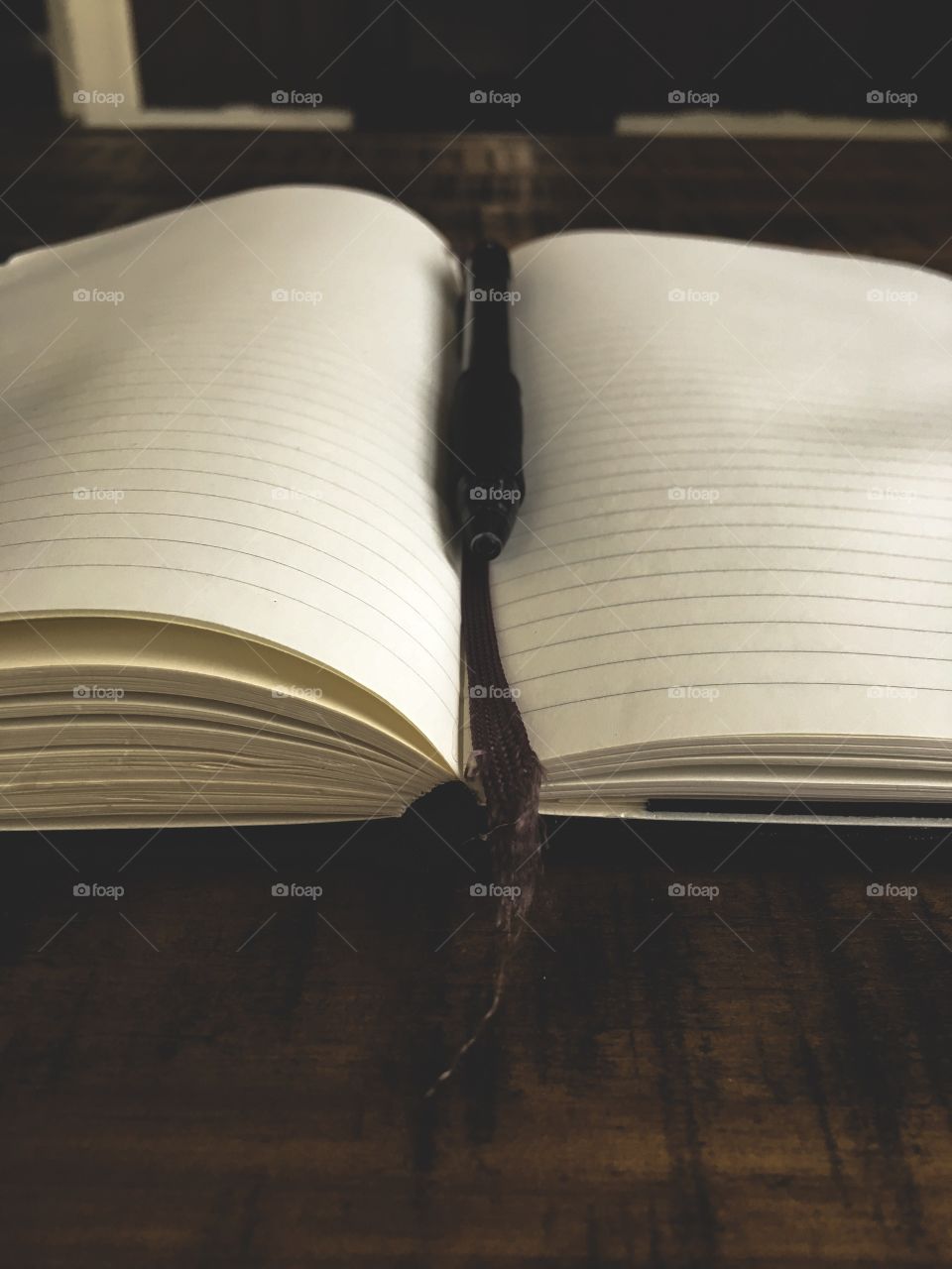 Vintage notebook open to a blank page on a wooden table at a library 