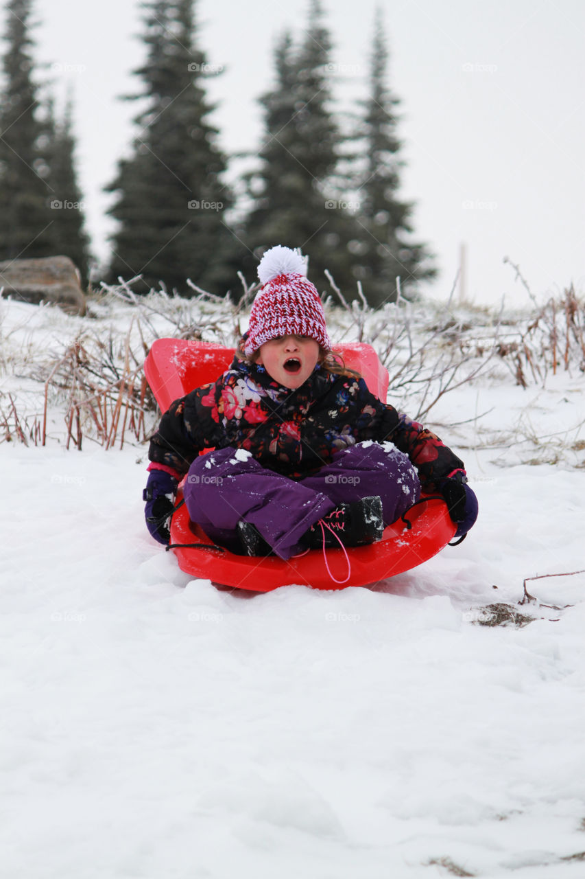 Child sledding down a hill