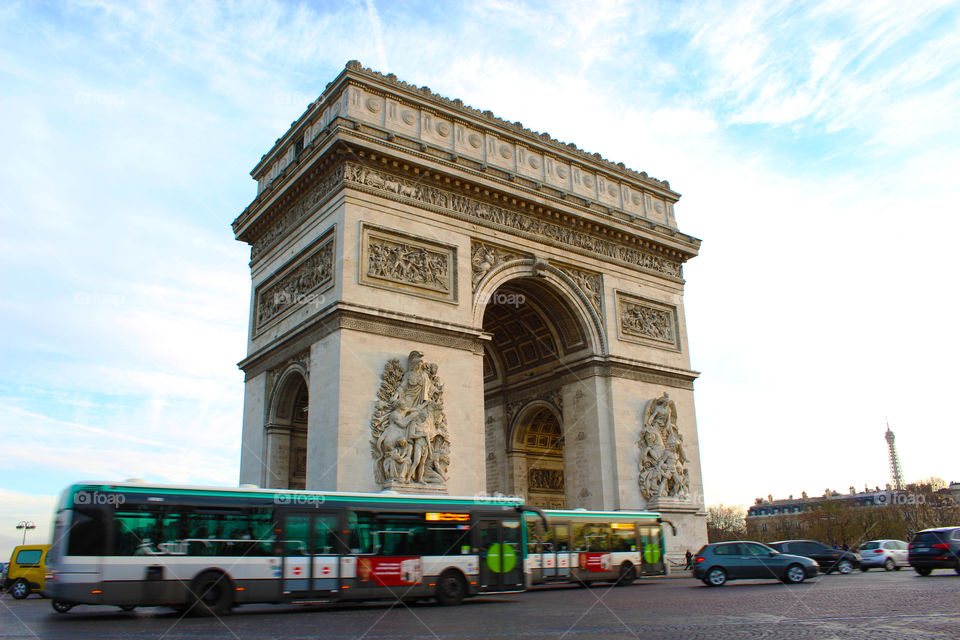 Buses ride around the arch of Triumph in Paris,France