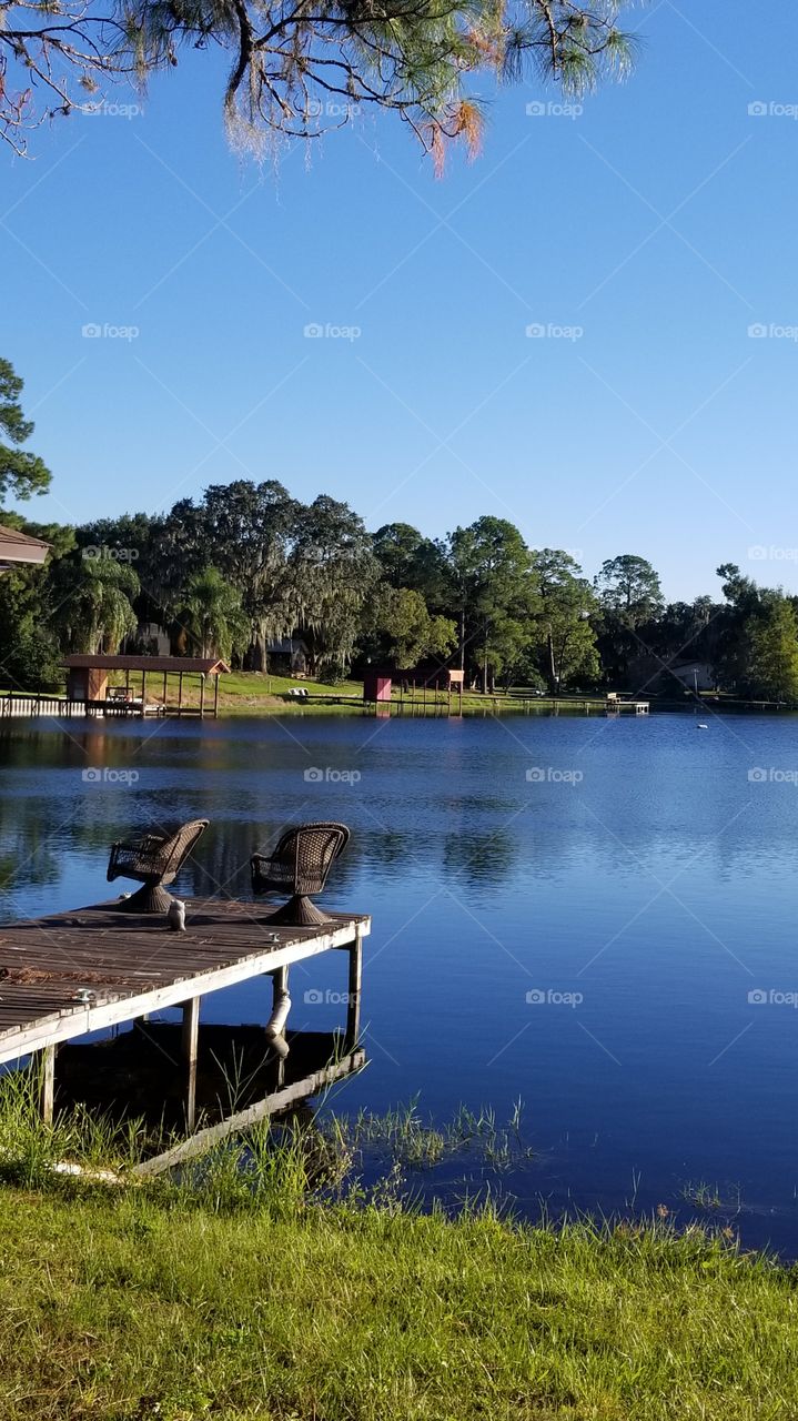 Chairs on a Dock By the Blue Water of a Lake for Relaxation