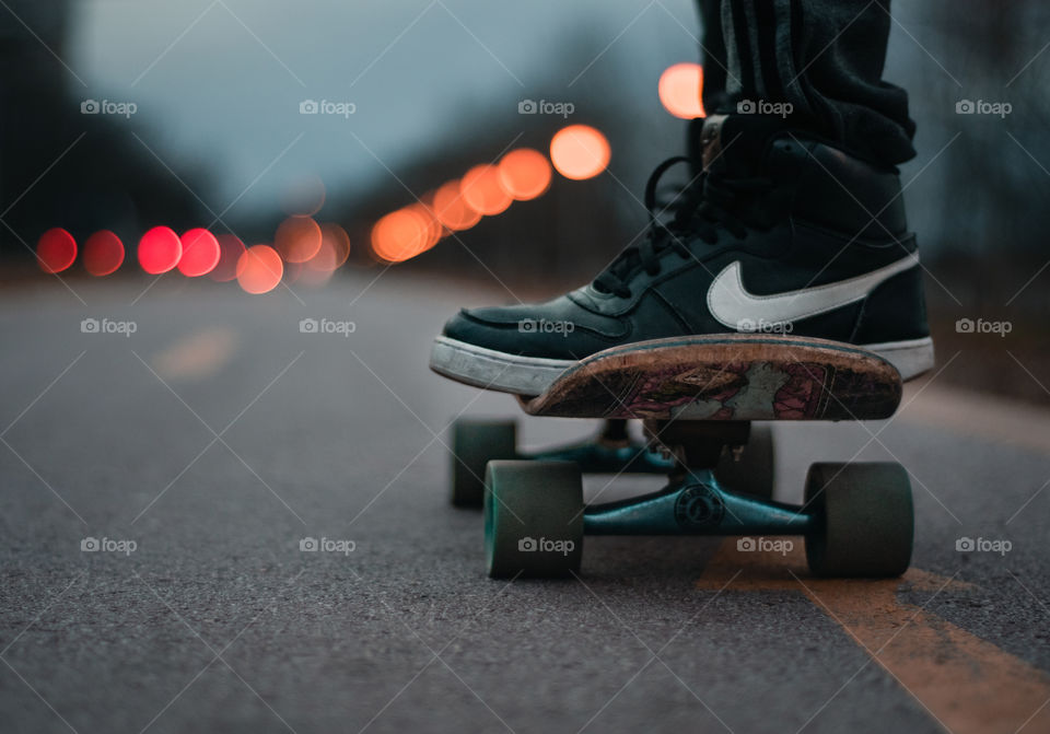 Boy on a skate going down the road.