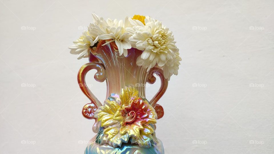 Beautiful white flowers in a colourful flowerpot with a flower sculpture, Flowers in a vase, colourful vase, white flowers in a vase