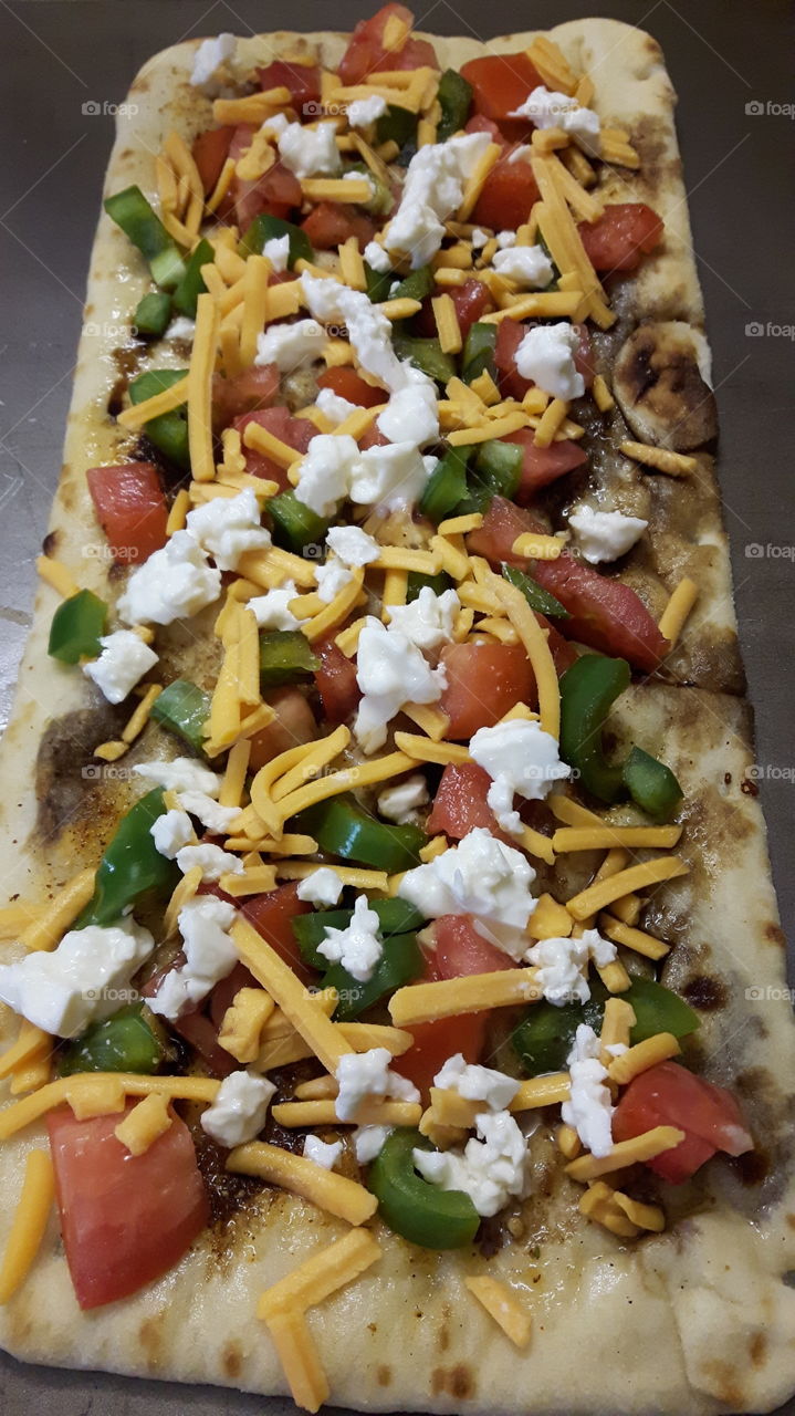 Flat bread with tomatoes green peppers and cheese