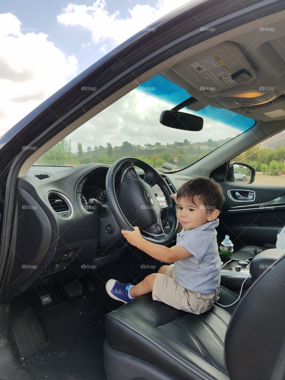 Toddler holding steering wheel