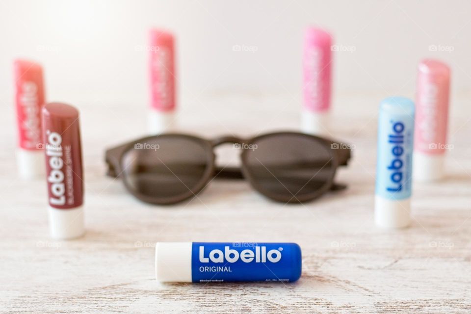 Labello beauty products in a circle around a pair of sunglasses 