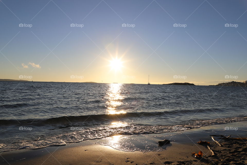 Bright sunlight illuminating the ocean and the sandy beach