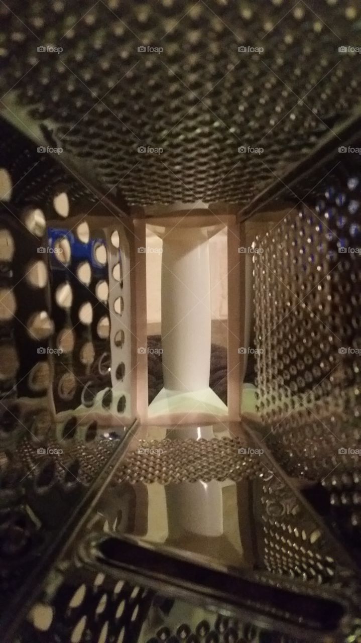 inside of a cheese grader.  I was cooking baked potatoes. I needed a cheese grader. when I was reaching for a plate in my cabinet, I hit the grader. looked down,and happened to look inside the cheese grader. thought it was a cool image and took a pi