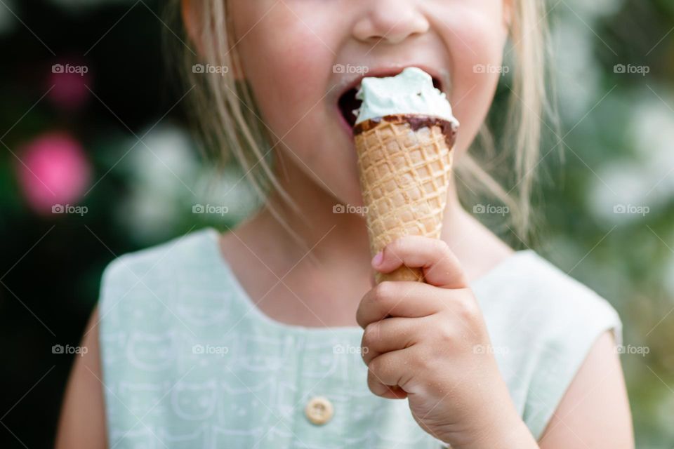 Kid eating icecream outdoor at summer day 