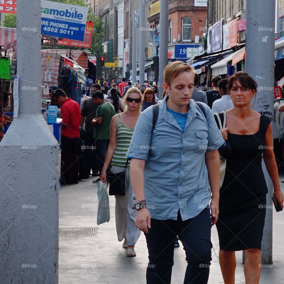 Crowds of people out walking, shopping, and eating, on European streets on a summer day. 