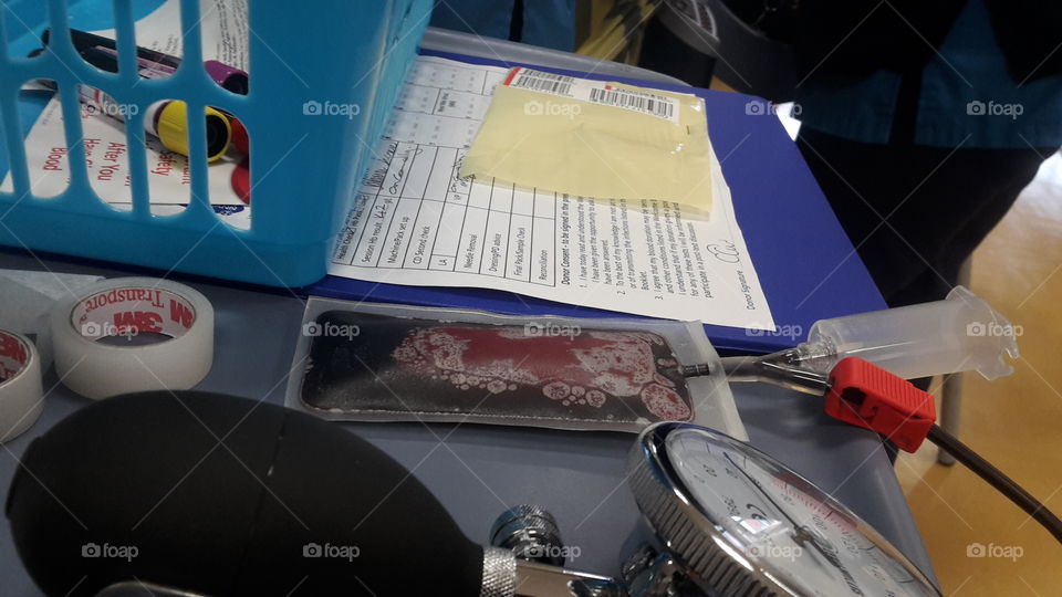 Pouch of blood on a blue table nhs giving blood sessions medical equipment in use with paperwork