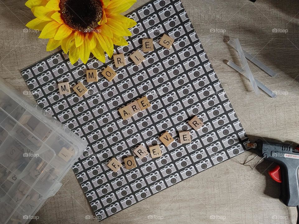 Memories are Forever with Camera Paper Letters Flower Glue Gun being created in the desk top