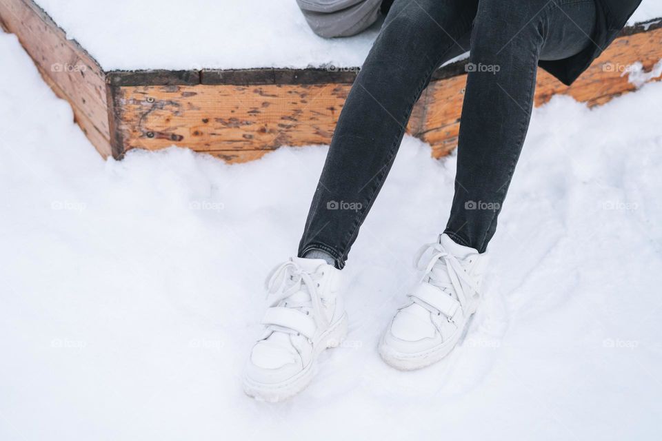 Young woman with mobile phone in white Dr. Martens boots in winter 