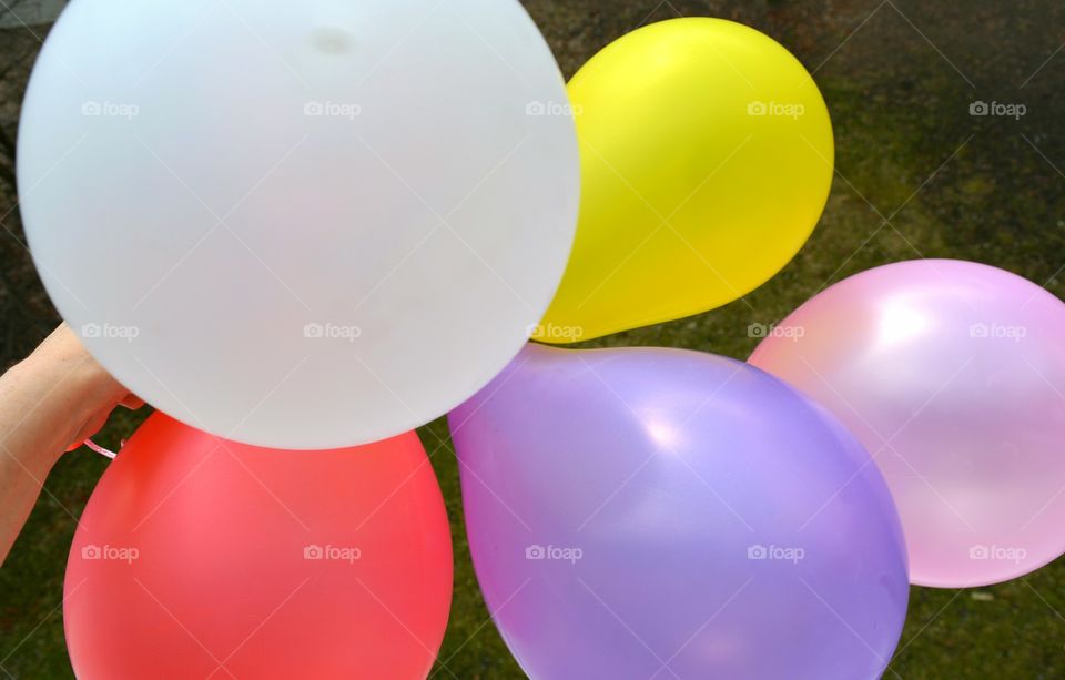 colorful balloons in the hand green summer background