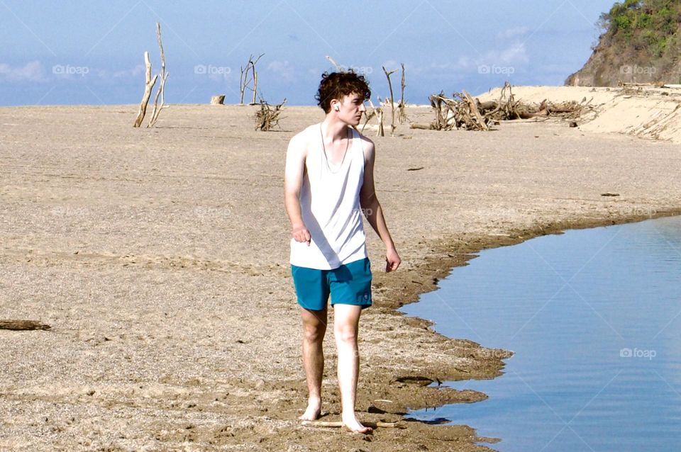 A young man walks along the back bay in Lo De Marcos beach.