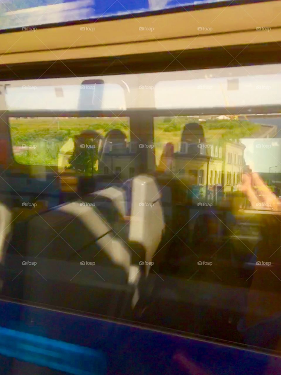 A train passes another, shot is of interior of train at speed. The view beyond is visible.