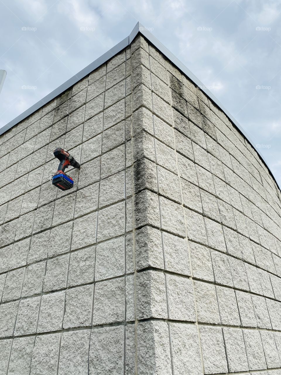 A drill left hanging from a concrete building