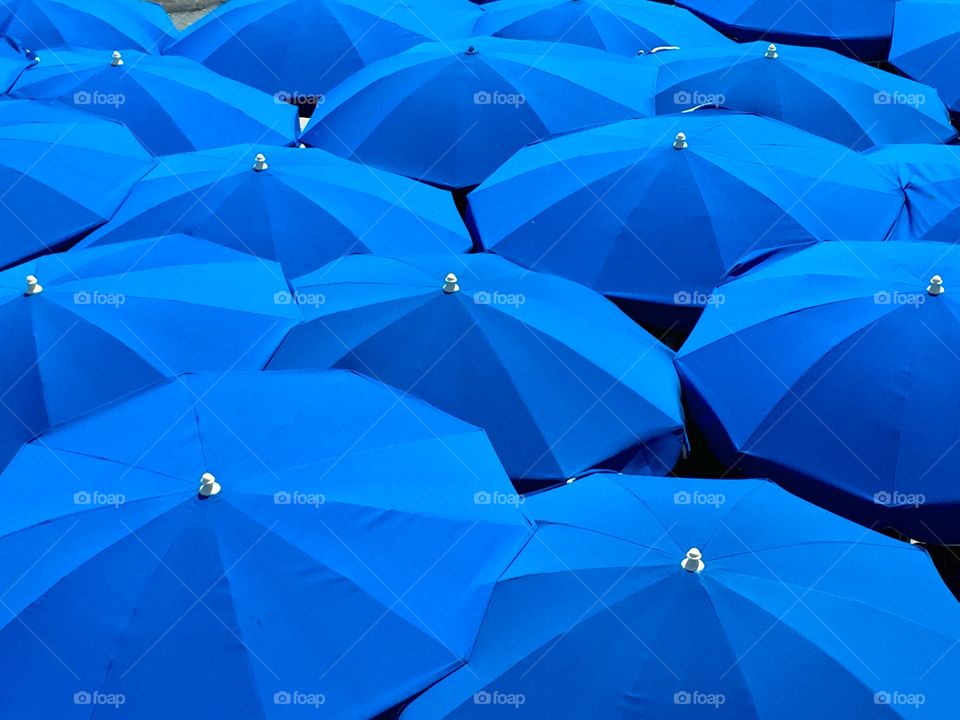Bright blue umbrellas at the beach in southern France. 