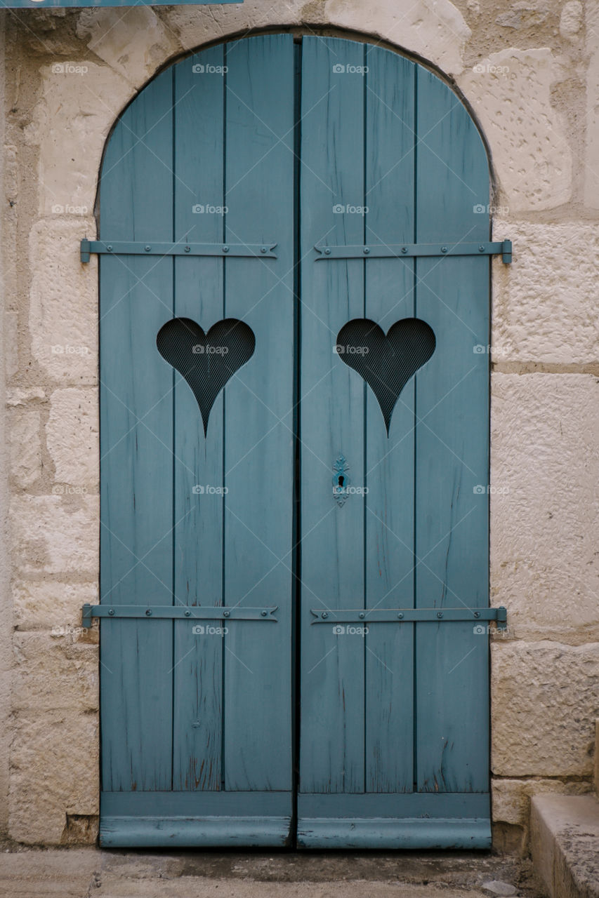 Blue love heart arched door in French village 