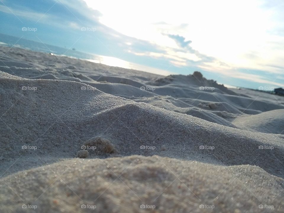 sand dunes with highlights and lowlights along the sparkling sea shore
