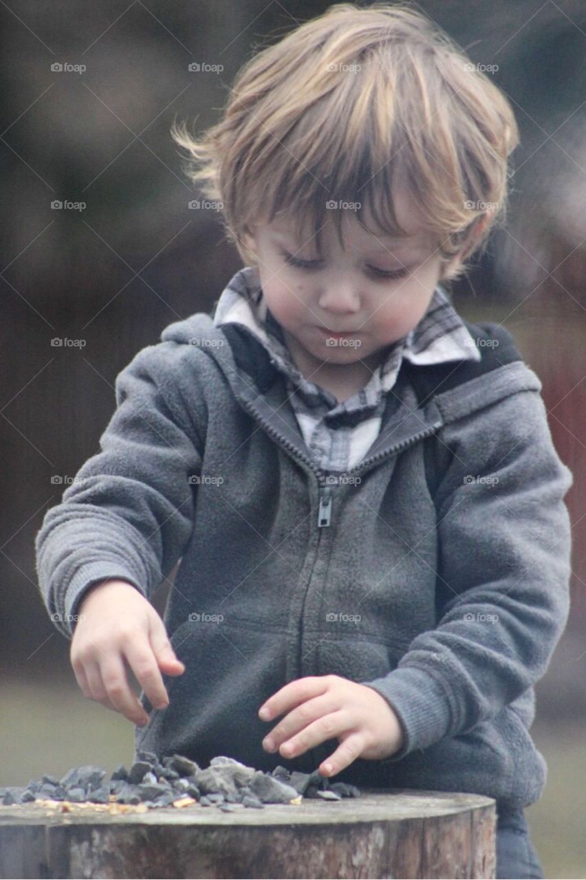 Close-up of a boy playing with stones