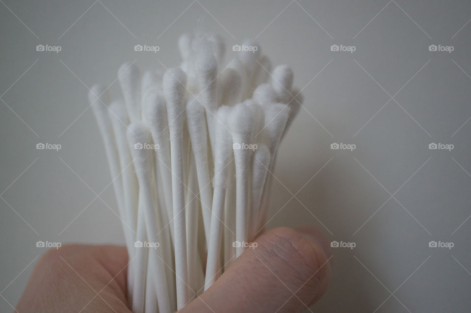 Hand holds some cotton swabs
