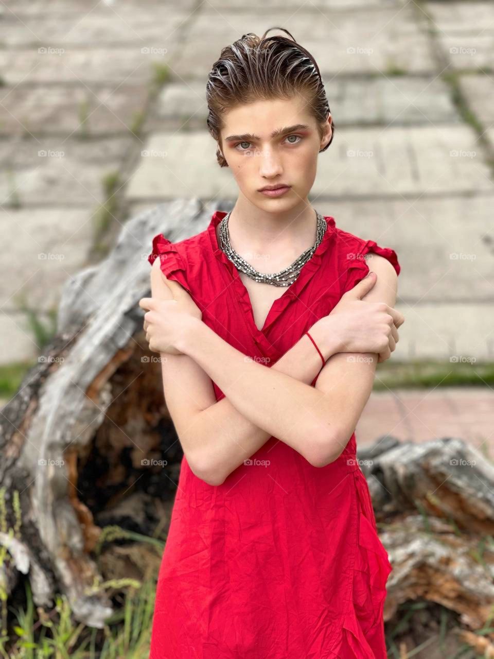 Beautiful non binary boy girl in red dress.