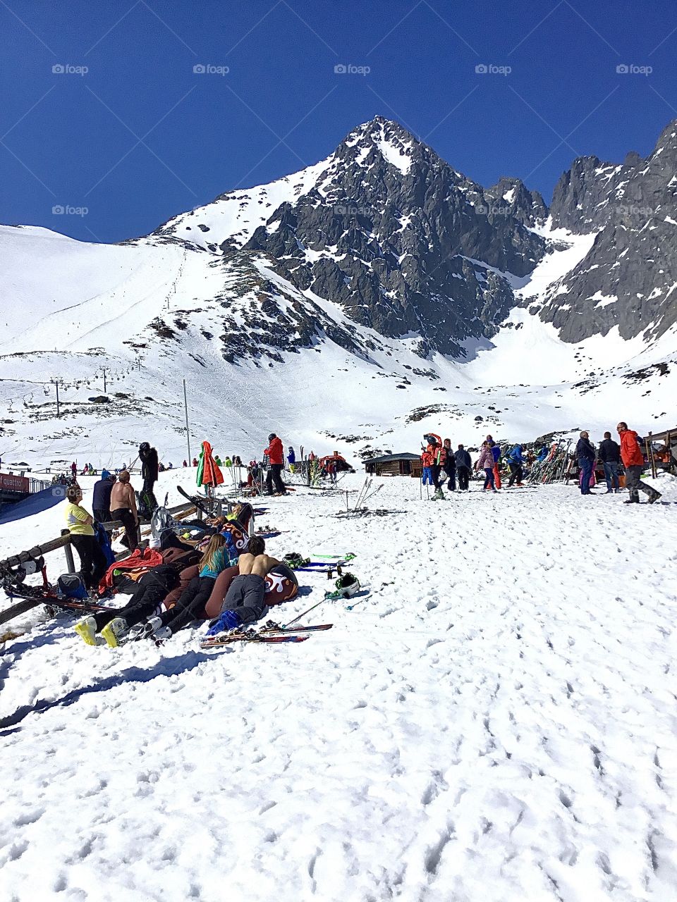 Landscapes of 2019 - Foap Missions - Skiers resting and sunbathing in the warm sun at the base of the High-Tatras (Vysoké Tatry)