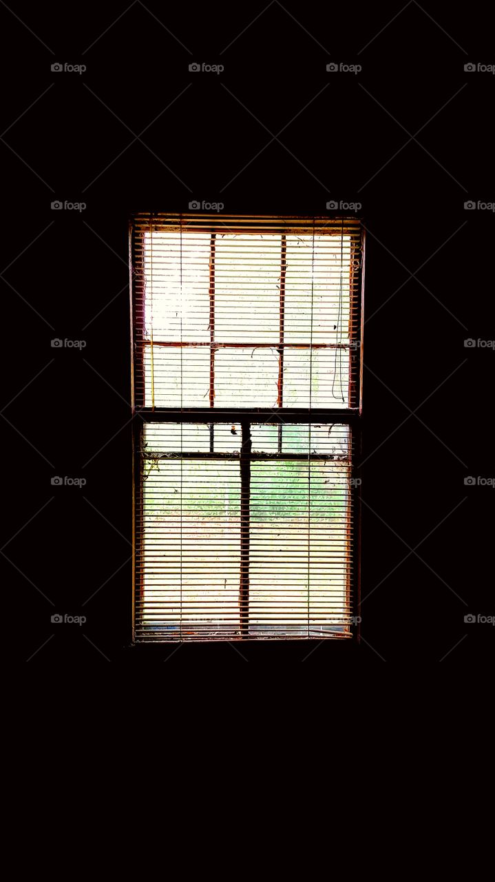 Window inside abandoned House. The filtered light giving life back to an otherwise dead room drenched in darkness.