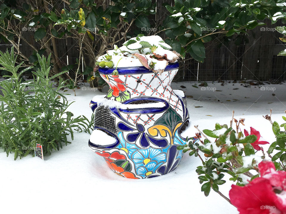 Talavera flower pot for strawberries, brightly decorated mexican flower pot in snow on cold winter day