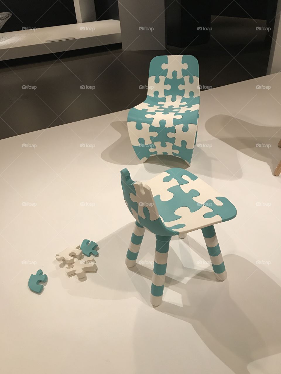 Two blue and white chairs made out of jigsaw pieces 