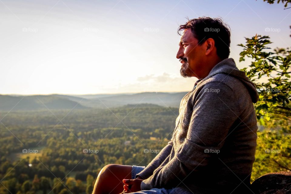 Men is meditating on the top of the mountain