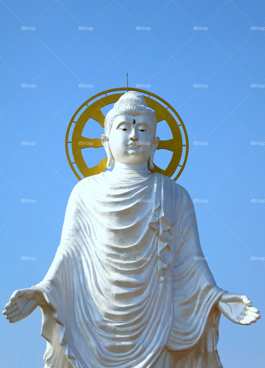 Big white​ standing​ buddha​ statue​ located​ in​ Buddhism Temple, Thailand.