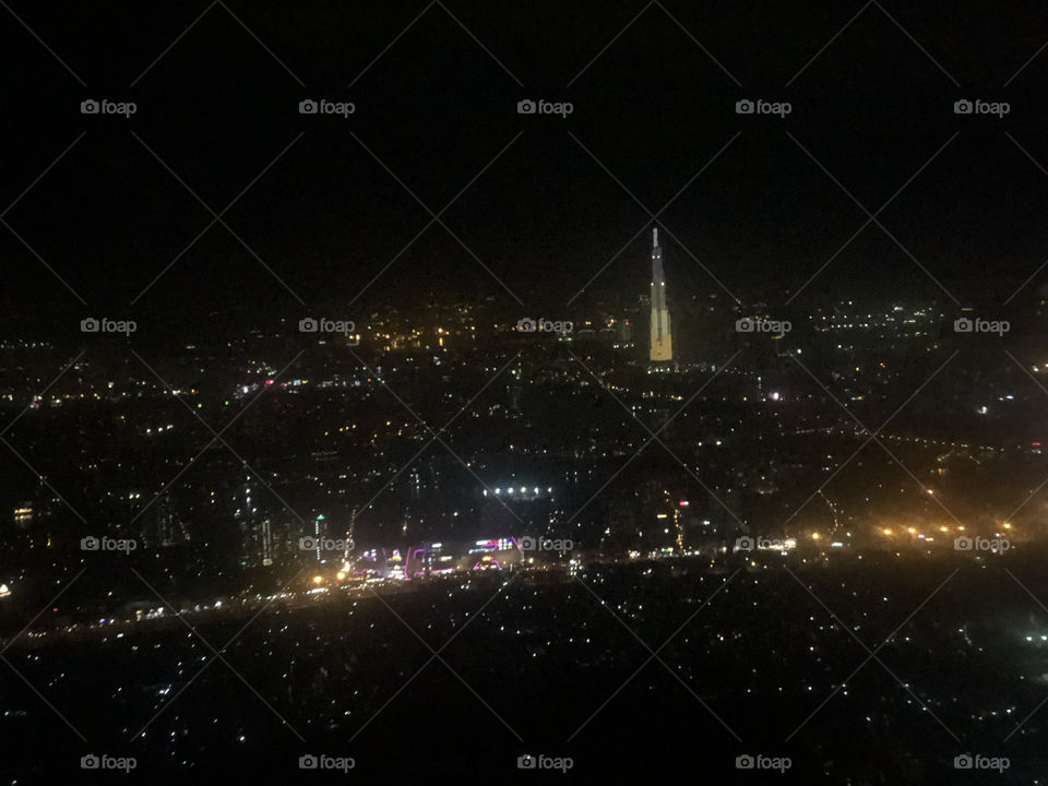Ho Chi Minh City at night when viewed from up above. The tall and bright building is landmark 81