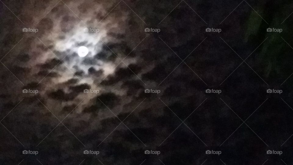 Breathtaking full moon in a cloudy night sky