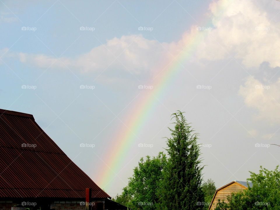 rainbow in the sky in July, hot weather, rain soon