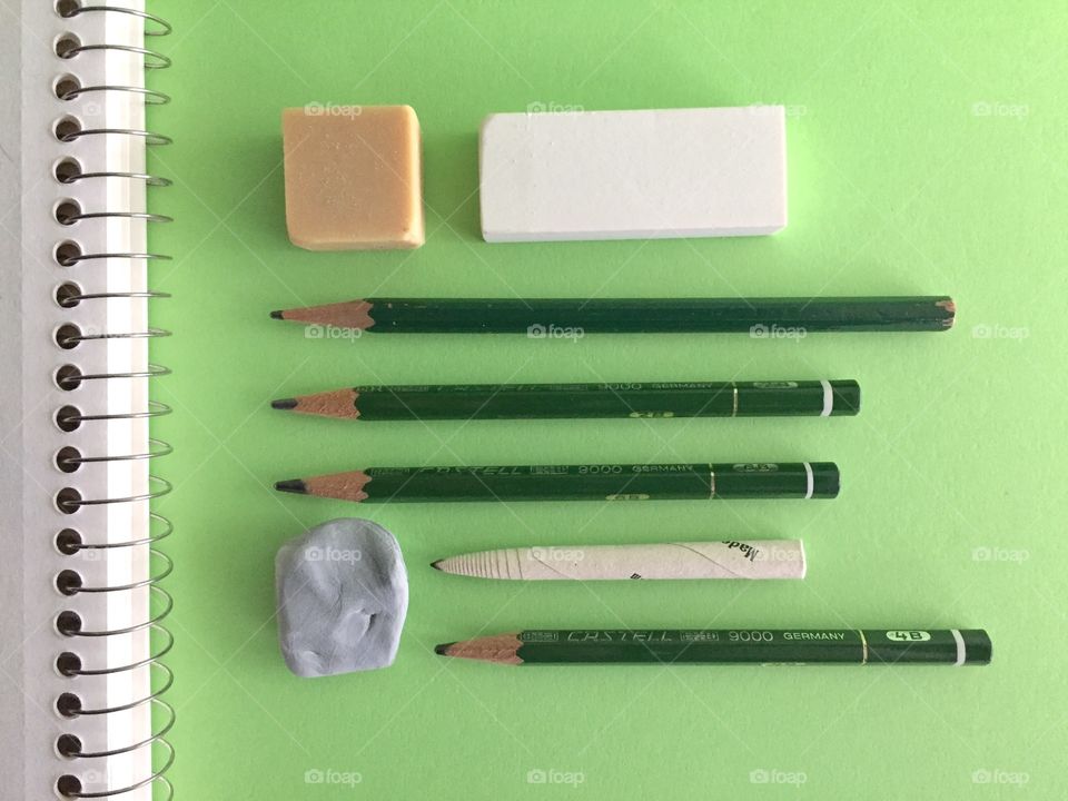 Pencils and eraser on green background