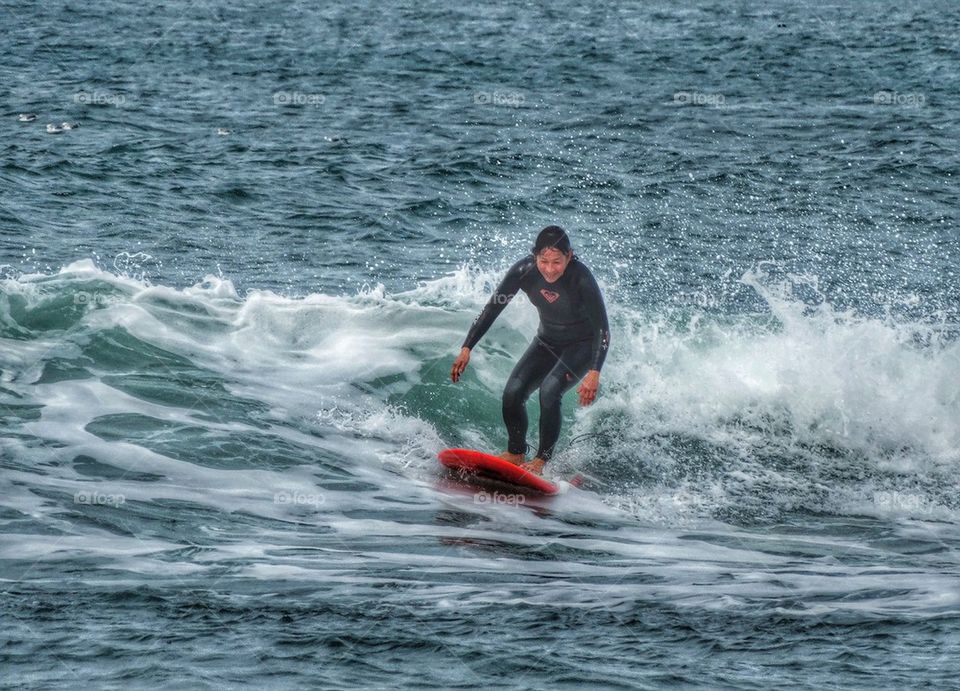 Grandmother Riding A Surfboard. Old Lady Riding A Surfboard
