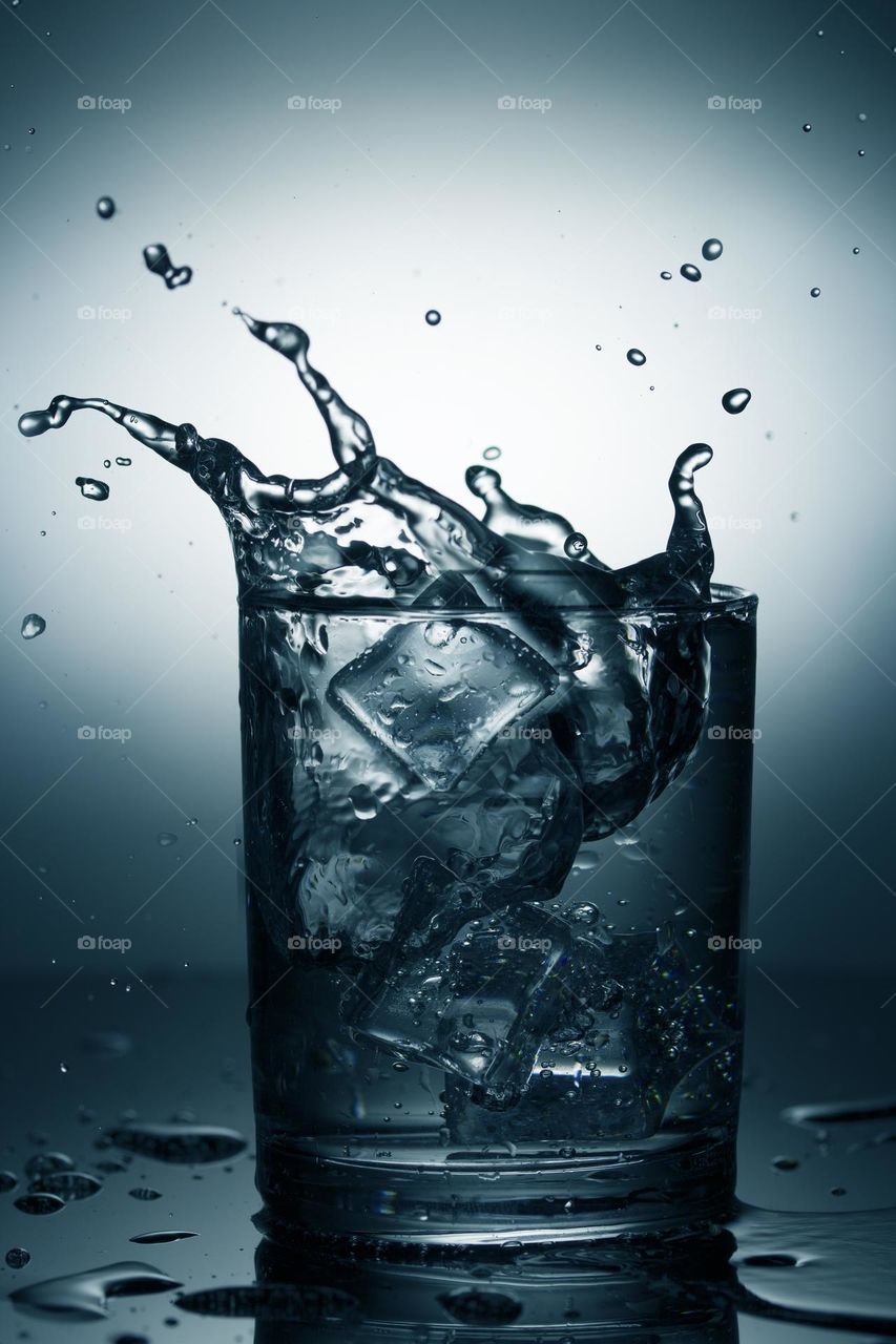Glass of mineral water with ice and splash .